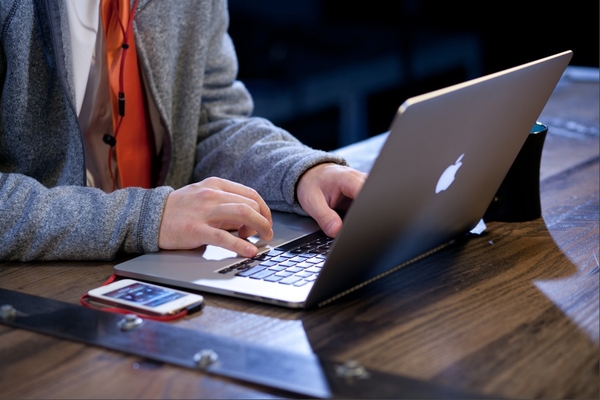 Hands on a laptop & mobile device to show how sales tools are used.