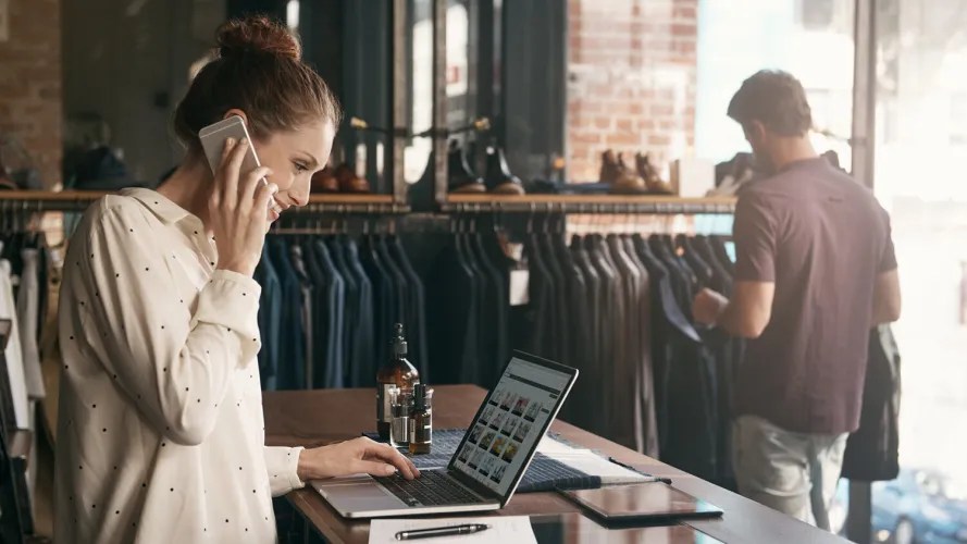 A salesperson at a clothing store looks at her computer: website personalisation