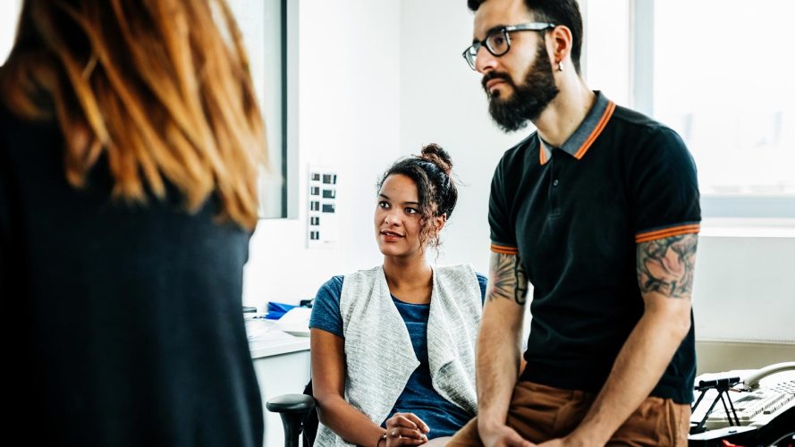 three people talking in an office