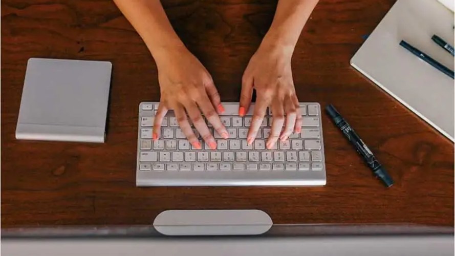 Hands typing on a computer keyboard