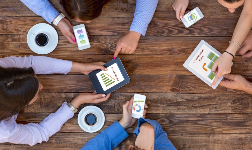 business people around a table trying to make an impact with social media