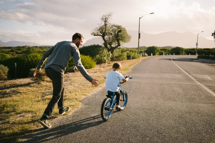 Father teaching son how to ride a bike