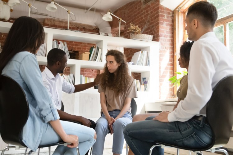 a team meeting where coworkers are listening and supporting one another