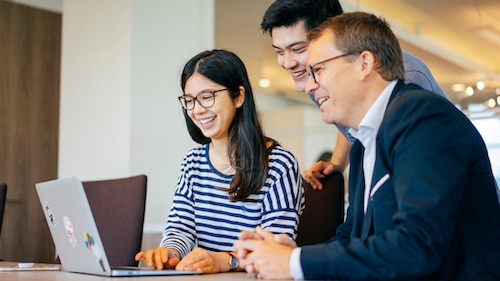 Photo of colleagues viewing information on a laptop