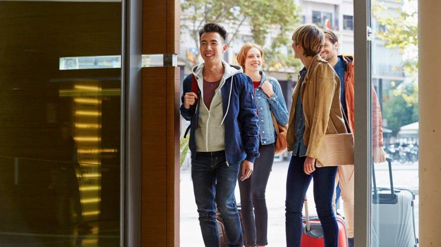 4 friends entering a hotel with luggage data datorama b2c marketing