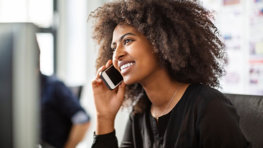 A woman speaking on a phone, something sales automation could free up more time to do.