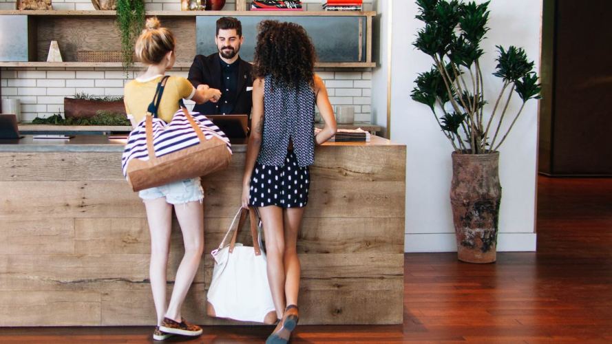 two people with shopping bags and a retail associate in a brick-and-mortar shop