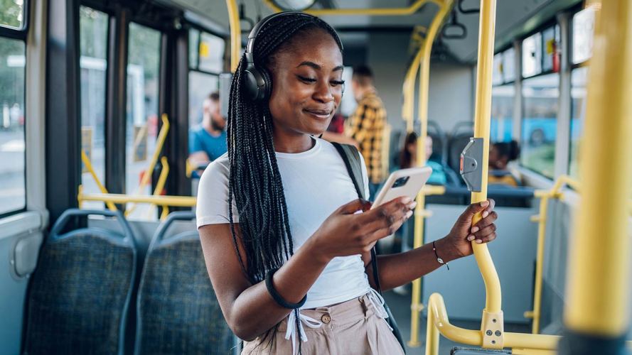 Female customer uses her mobile device on a subway.