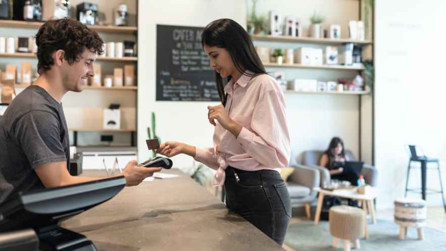Customer using their loyalty value program card in a coffee shop