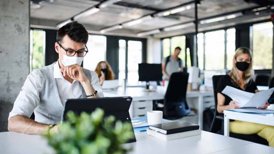 Workers don face masks in their office