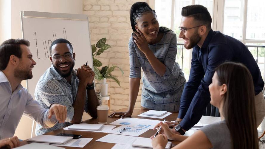 a group of smiling people around a conference table