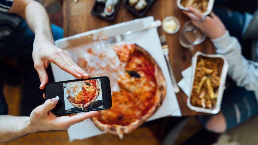 Man photographs his pizza