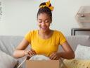 A woman opens a delivery box, the impact of ecommerce on retail industry.