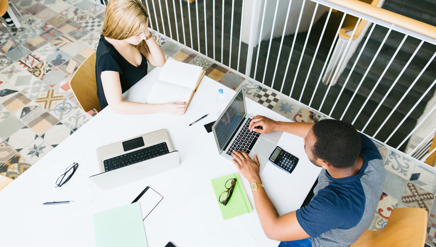 vrouw en man die op hun kantoor op hun laptop bezig zijn