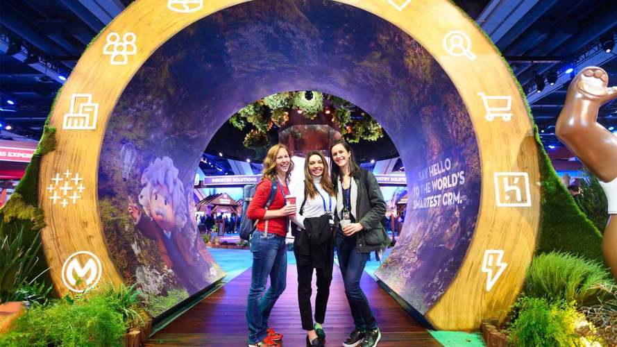 Three people standing at the entrance to the Dreamforce campground