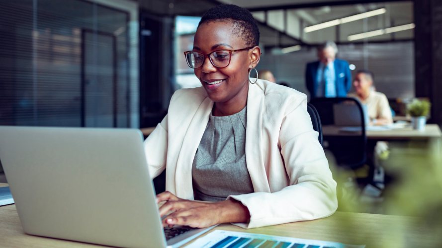 A woman sitting at a desk typing on a computer. B2B marketing campaign