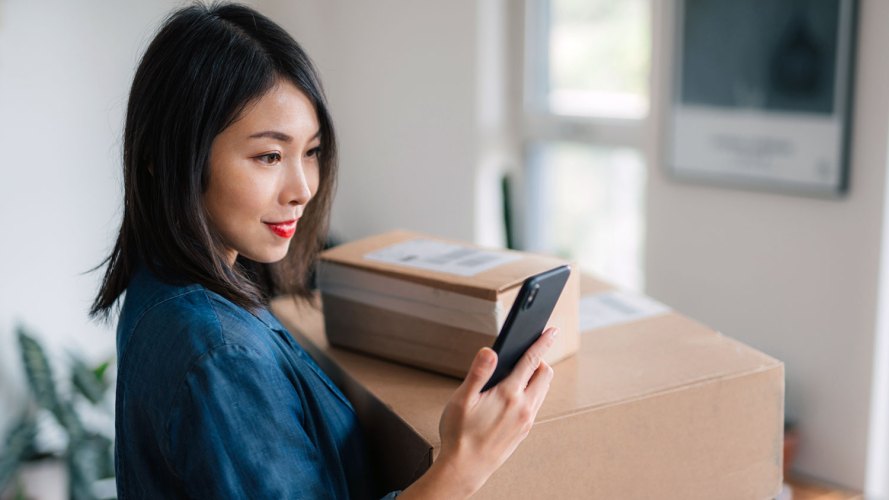 A woman looking at her phone, perhaps a business customer using B2B search.