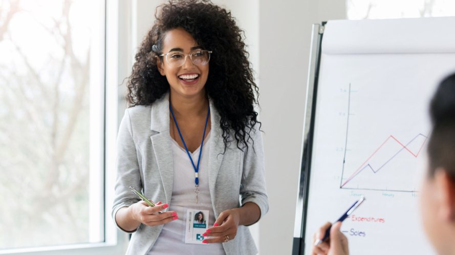 A woman stands next to a chart in a business meeting: economic recession