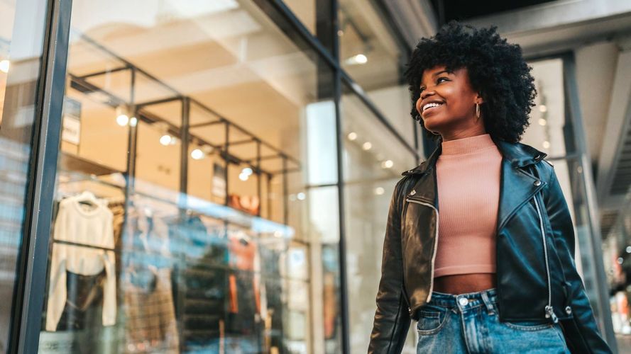 A young woman looks through a store window: Millennials vs. Gen Z