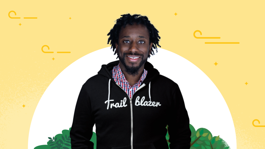 Trailblazer Marvin Cross in the iconic black Trailblazer hoodie stood against a yellow background.