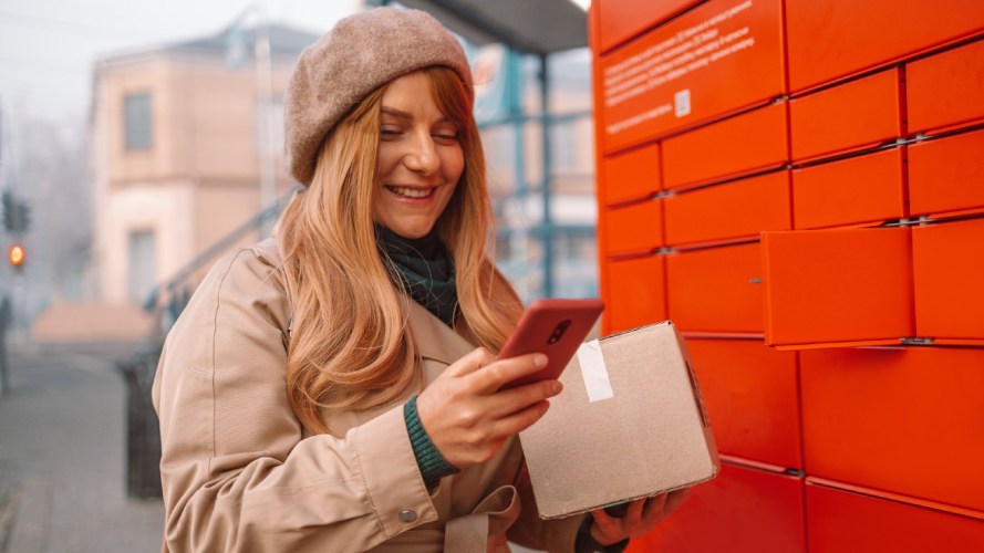 A woman taking a package out of a self-service locker