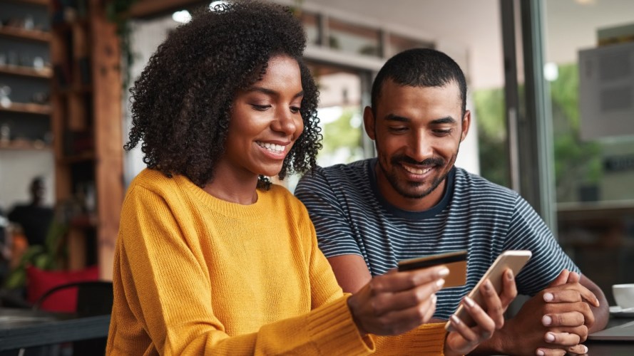 Image of two people completing an online transaction with a credit card: ecommerce architecture