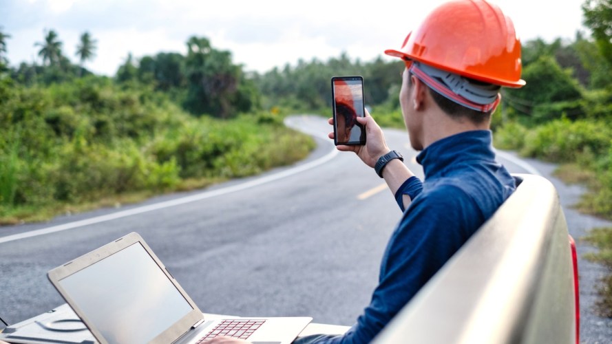 A worker holds a laptop in his lap while conducting a video call: mobile offline access.