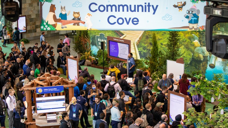 Trailblazer Community at Dreamforce gathering underneath a big Community Cove Banner