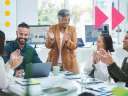 A group of people in a conference room celebrate Customer Service Week.