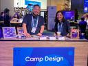 Two Salesforce employees smiling at the Camp Design welcome desk.