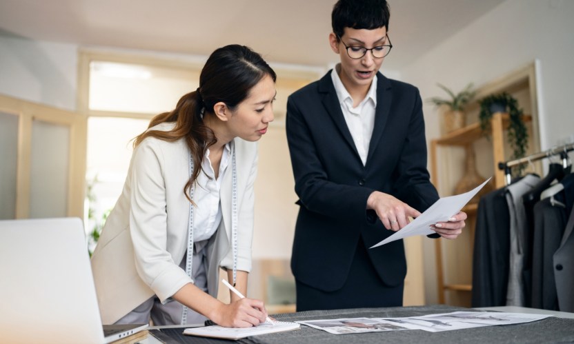 Two women reviewing a business proposal for SMB over a desk.