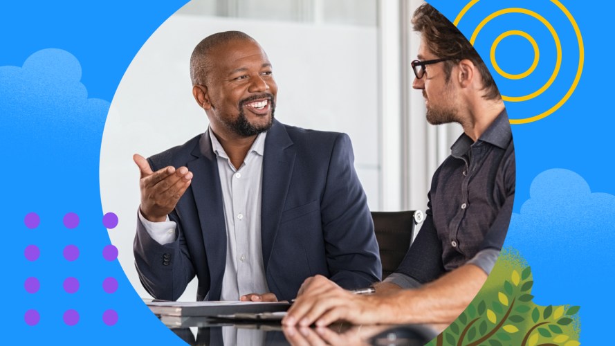 A sales rep asking high-gain questions to a prospect, smiling and sitting at a table.