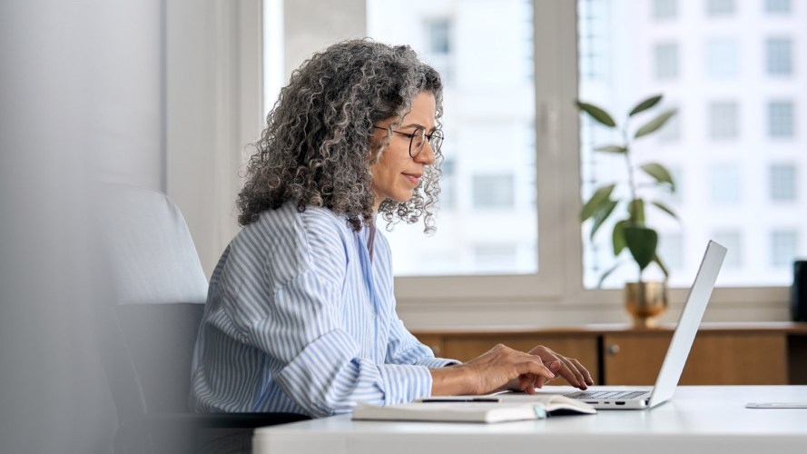 Image of a woman working on her computer at her desk / B2B data