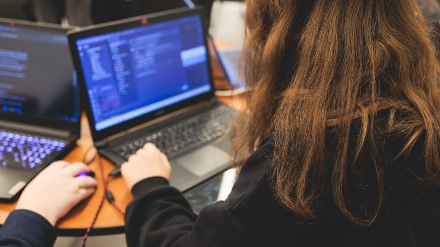 Female software developer students working on computer and laptop