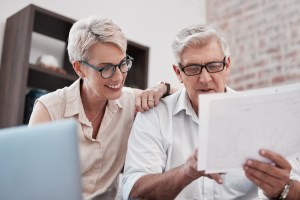 Casal sorri enquanto olha para o smartphone