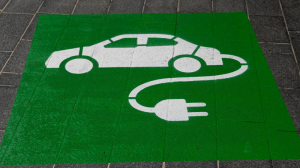 Auf einem gepflasterten Boden ist ein grüner Aufdruck mit einem E-Auto zu sehen