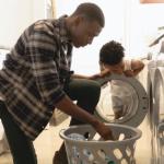 Un padre con su hija poniendo la lavadora