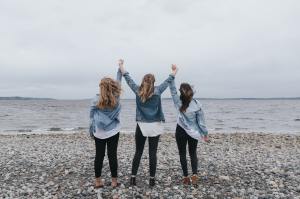 3 mujeres alzando los brazos