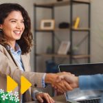 Photo of a woman shaking hands, utilising sales closing techniques during a sale