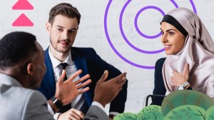 Three people smiling during a price negotiation on a purple illustrated background