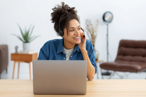 Mujer en su computadora haciendo un atendimiento al cliente por su headphone.