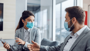 two salespeople talking in masks