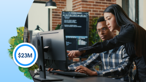 Two hackers collaborate in front of a computer monitor.